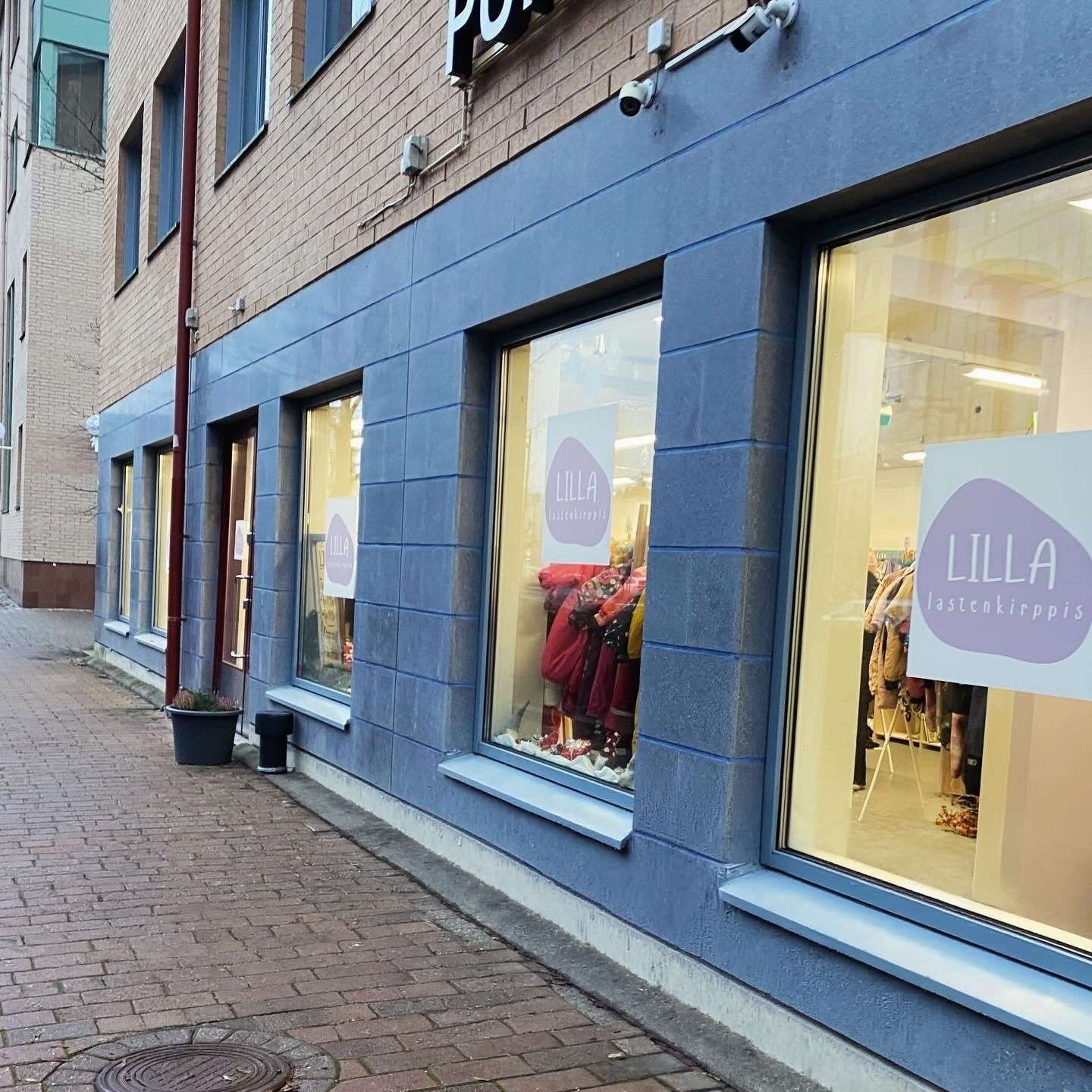 Rakennuksen katutasossa n&auml;kyy liiketila, jonka ikkunoissa on tekstit &ldquo;LILLA lastenkirppis&rdquo;. Ikkunoiden l&auml;pi n&auml;kyy lastenvaatteita rekiss&auml; ja esille aseteltuna. Rakennuksen sein&auml; on alaosasta sininen ja yl&auml;osasta tiiliverhoiltu. Yl&auml;puolella on osittain n&auml;kyv&auml; kyltti &ldquo;POHJAN&hellip;&rdquo;. Kuvassa on my&ouml;s kapea mukulakivinen k&auml;velytie rakennuksen vieress&auml;.