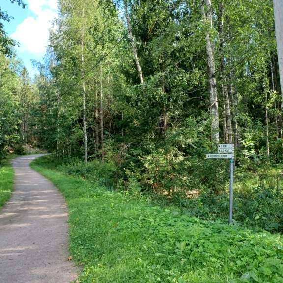 Mets&auml;inen kuntorata kulkee vehre&auml;ss&auml; ymp&auml;rist&ouml;ss&auml; opastekyltin vieress&auml;.